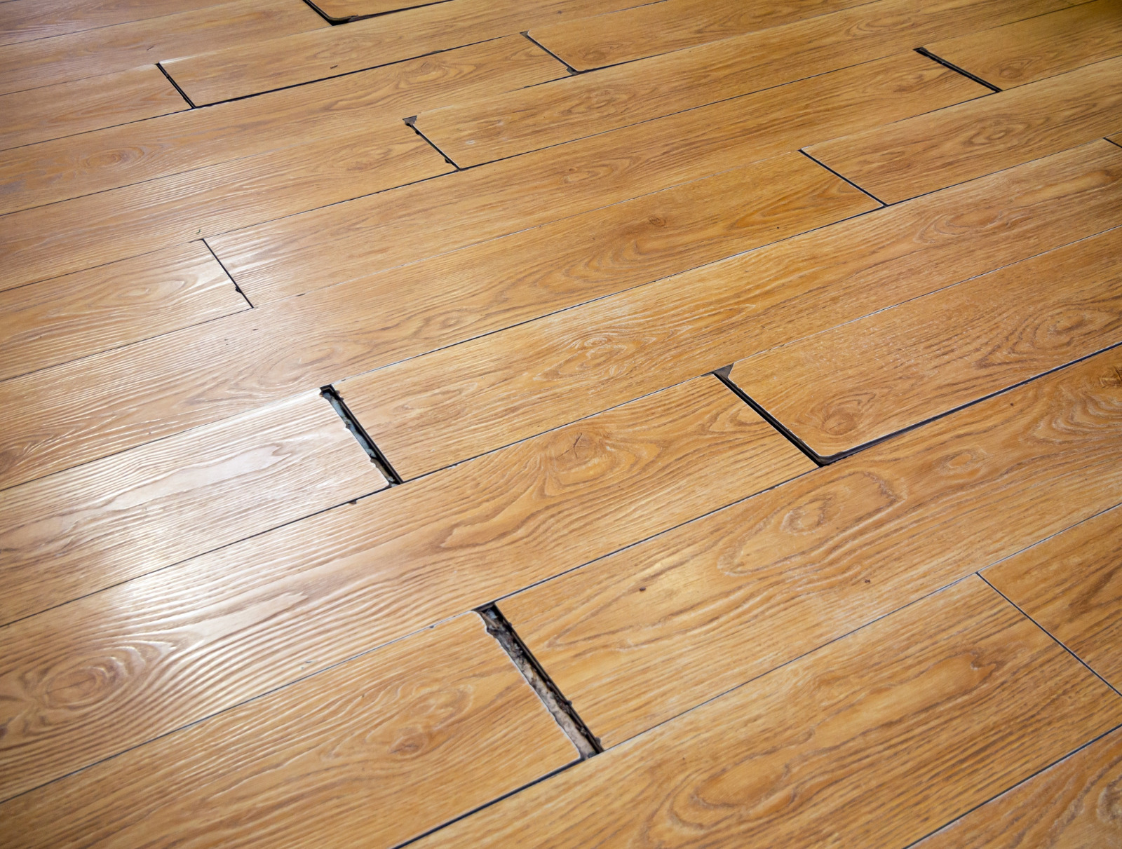 Southwark close-up of an Engineered European Oak hardwood floor with lifted planks and open joints before repair—Gap Strip Magic will seal, stabilise and refinish.