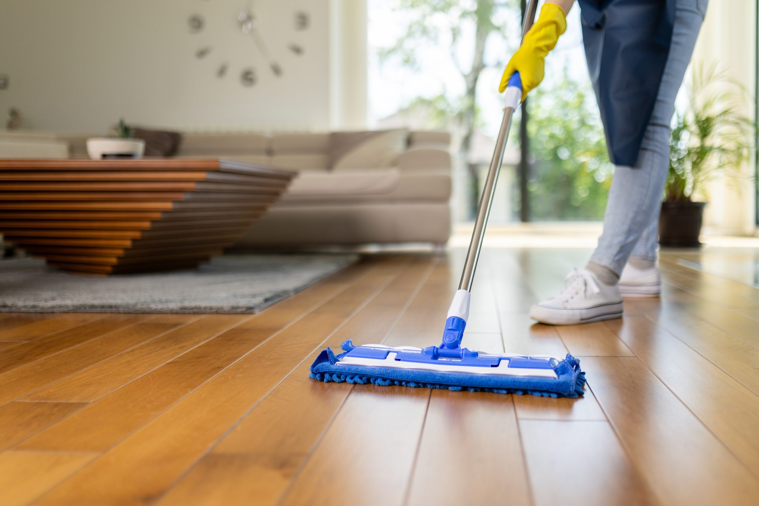 Southwark living room with an Engineered European Oak plank floor being wiped with a flat microfibre mop—Gap Strip Magic has sealed the seams for an easy-clean, draught-free finish.