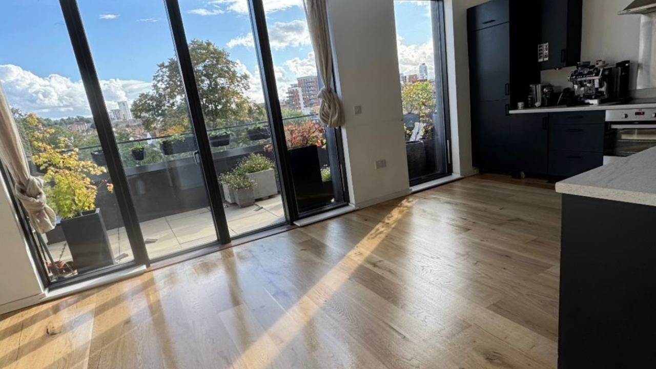 Southwark open-plan kitchen with floor-to-ceiling glazing; Engineered Oak Plank Floor restored after Gap Strip Magic, showing a smooth, sunlit, seamless finish.