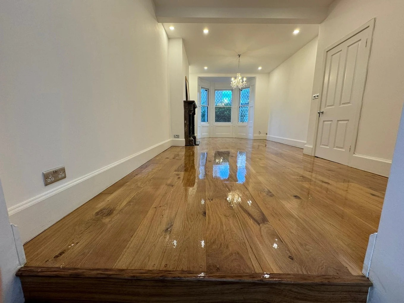 Hardwood Floor Refinishing in Southwark – engineered oak wide plank hardwood floor in a long living and dining room, restored to a high-gloss, mirror-like finish.